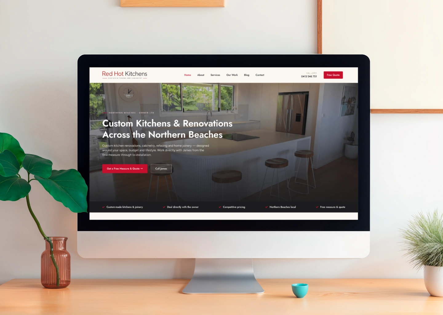Desktop monitor displaying a kitchen-renovation website with a dark hero image and the headline about custom kitchens.